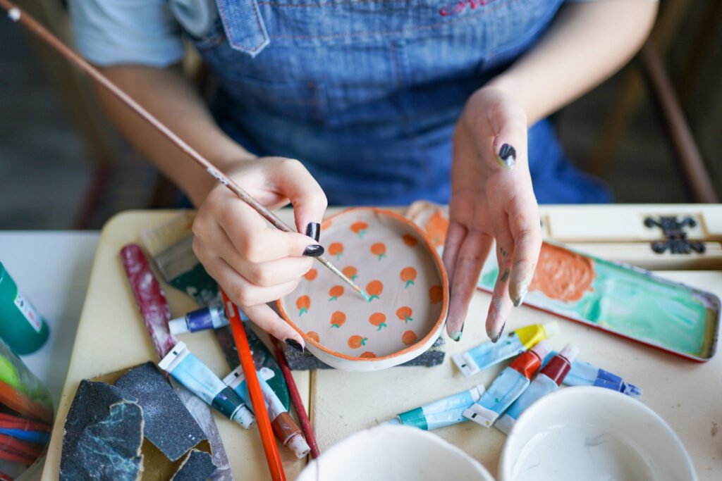 woman hand paints ceramics