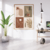 Modern boho botanical wall art with earthy abstract floral and leaf designs in a wooden frame, displayed in a bright minimalist home office with a potted plant, wooden desk, and white brick wall.