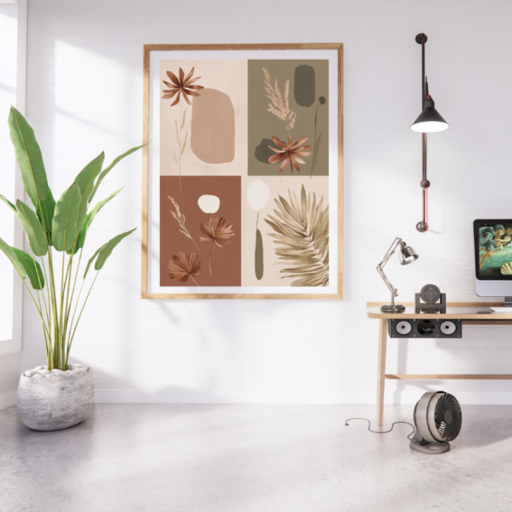 Modern boho botanical wall art with earthy abstract floral and leaf designs in a wooden frame, displayed in a bright minimalist home office with a potted plant, wooden desk, and white brick wall.