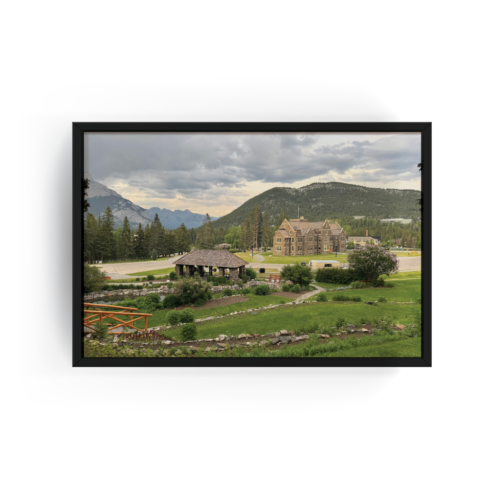 Horizontal Banff cityscape print with black frame featuring panoramic mountain town view with stone buildings