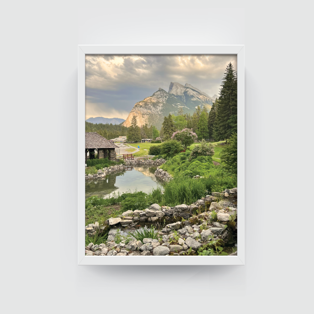 Vertical Banff cityscape print with white frame highlighting greenery and cloudy sky over Alberta town