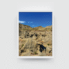 Vertical white-framed Canadian Badlands landscape featuring eroded cliffs and layered hills at Dinosaur Provincial Park.