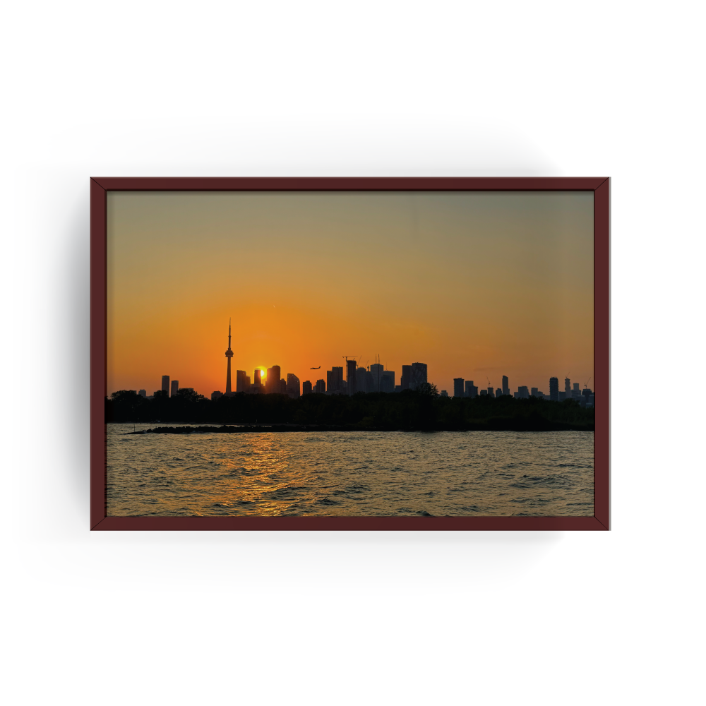 Toronto sunset cityscape print in a rich espresso wood frame, showcasing the CN Tower and glowing skyline reflected in Lake Ontario during golden hour.