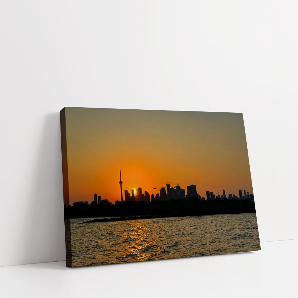Toronto sunset skyline printed on premium stretched canvas, featuring the CN Tower, shimmering city lights, and golden hour colors over Lake Ontario.