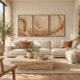 Three-piece travertine architectural triptych canvas print set in natural blonde oak floating frames above an ivory sectional sofa with camel leather pillows